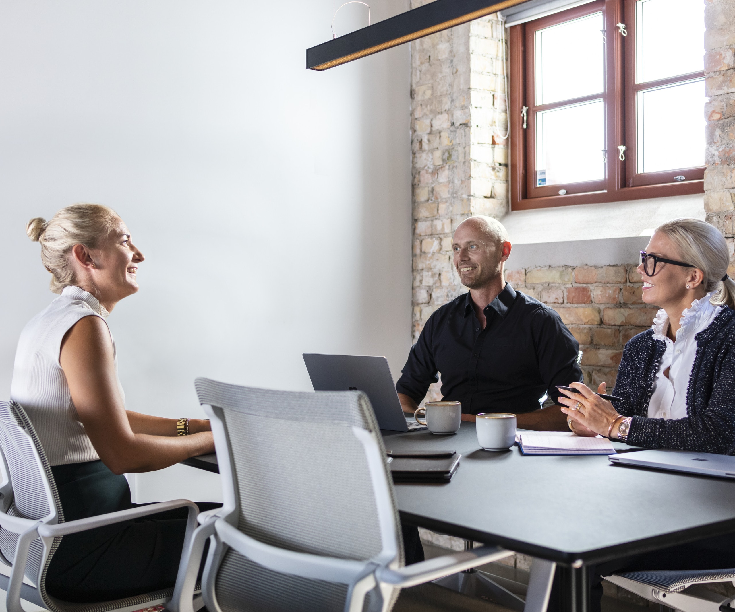Three people sitting around a table.